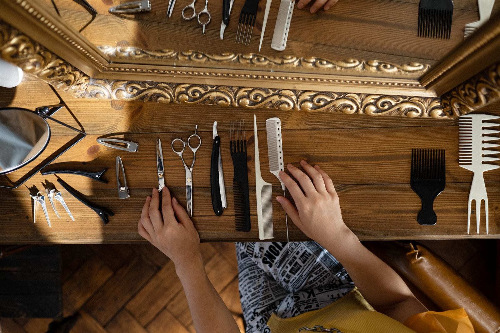 Peignes, ciseaux et outils de coiffure disposés devant un miroir