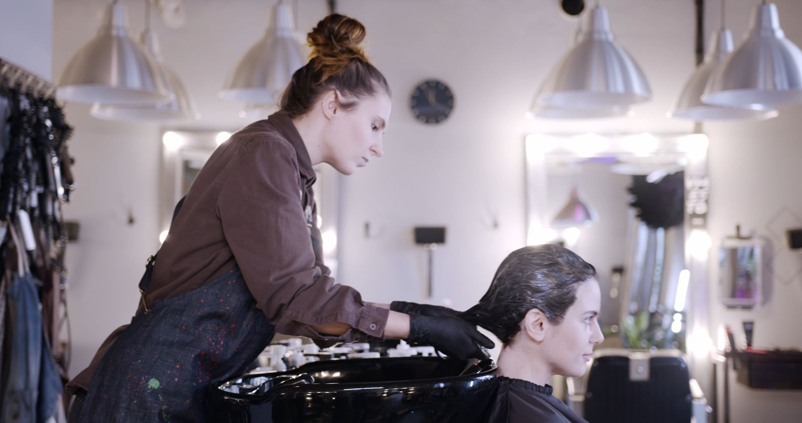 Coiffeuse pratiquant un shampooing sur un bac de lavage